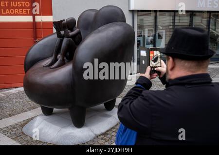 Rakovnik, République tchèque. 14 novembre 2024. Le peintre et sculpteur Jaroslav Rona (non vu) a dévoilé sa sculpture "le lecteur dans la chaise" devant le bâtiment du Centre d'études et de services sociaux polyvalents à Rakovnik, république tchèque, le 14 novembre 2024. Crédit : Ondrej Deml/CTK photo/Alamy Live News Banque D'Images