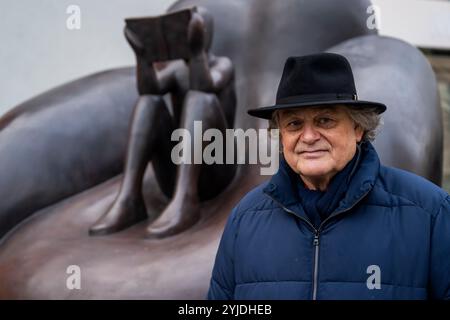 Rakovnik, République tchèque. 14 novembre 2024. Le peintre et sculpteur Jaroslav Rona a dévoilé sa sculpture "le lecteur dans la chaise" devant le bâtiment du Centre d'études et de services sociaux polyvalents de Rakovnik, république tchèque, le 14 novembre 2024. Crédit : Ondrej Deml/CTK photo/Alamy Live News Banque D'Images