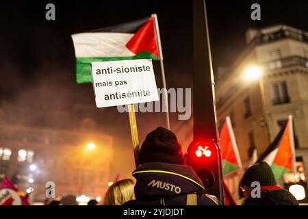 Un homme tient une pancarte qui dit "anti-sioniste mais pas antisémite", lors de la manifestation pro-palestinienne contre l'organisation du gala pro-israélien "Israël est pour toujours" à Paris. Des milliers de personnes ont manifesté à Paris contre le gala organisé par l’extrême droite en soutien à Israël, « Israël est pour toujours ». Le rassemblement, sous forte surveillance policière, était organisé par des partis de gauche et des syndicats, des mouvements juifs de gauche et des groupes pro-palestiniens. Bezalel Smotrich, le ministre israélien des Finances, connu pour ses positions extrêmes sur Gaza, qui devait participer à l’événement, ende Banque D'Images