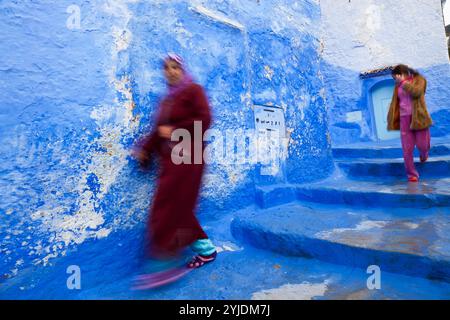 Femme et fille descendant les marches, Chefchaouen, Maroc Banque D'Images