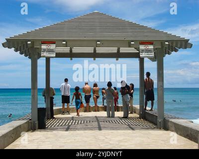 Waikiki, Oahu, Hawaï, États-Unis – vers juillet 2010 : les gens au bout de la jetée de ciment de la plage de Waikiki. Banque D'Images