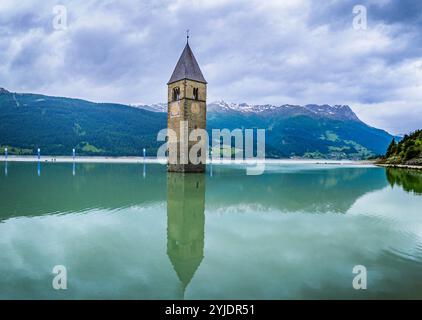 CURON VENOSTA, ITALIE – 27 AOÛT 2024 : le clocher emblématique de l’église submergée Curon Venosta s’élève des eaux du lac Resia, une Ré envoûtante Banque D'Images