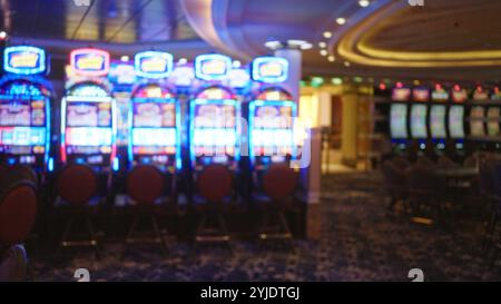 L'image floue montre des machines à sous de casino vibrantes avec des lumières colorées dans une atmosphère animée de Las vegas, capturant l'environnement de jeu en intérieur animé. Banque D'Images