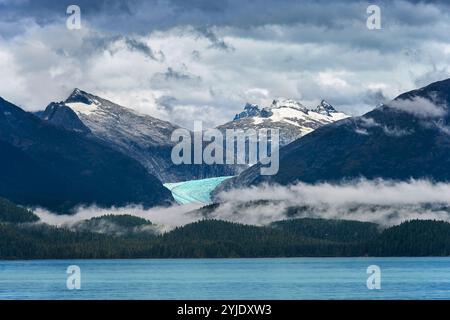 Vue sur l'océan d'une montagne enneigée avec un glacier de rivière en Alaska Banque D'Images