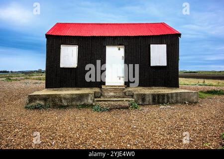 Le Fisherman's Hut, une charmante structure noire avec un toit rouge, se trouve à Rye Harbour, près de l'endroit où la rivière Rother rencontre la mer Banque D'Images