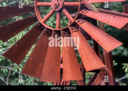 Moulin à vent fait maison peint en rouge utilisé comme décoration de cour. Un petit moulin à vent rouge brillamment peint est situé dans une cour avant Banque D'Images