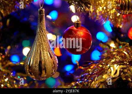 Sapin de Noël à boules argentées et rouges. Décorations festives de vacances sur un arbre de Noël. Banque D'Images