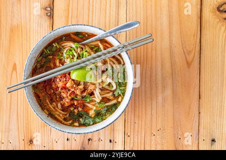 Khao soi Chiang Tung est servi dans un bol avec des nouilles de riz collantes et une soupe savoureuse de style Chiang Tung. Le délicieux Khao soi Chiang Tung i. Banque D'Images