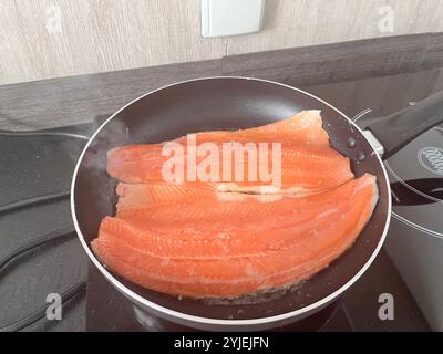 Cuisson maison de base de filet de truite de mer dans une poêle à frire Banque D'Images