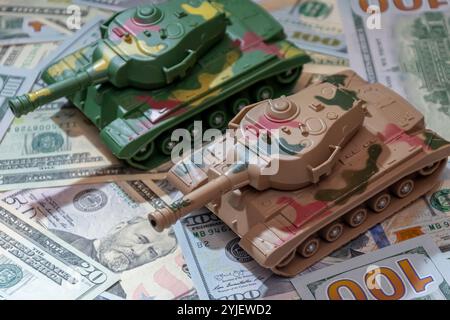 Deux chars militaires, dollars américains, gros plan. Concept : dépenses en armements, aide militaire, commerce des armes Banque D'Images