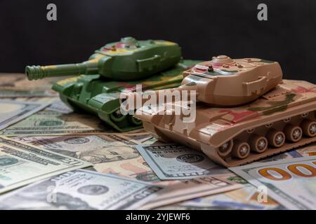 Deux chars militaires, dollars américains, gros plan. Concept : dépenses en armements, aide militaire, commerce des armes Banque D'Images