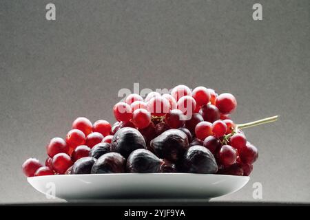 Assiette de raisins rouges frais et figues Banque D'Images