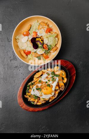 Petit-déjeuner à la poêle grésillante avec œufs et pommes de terre accompagnés d'une salade fraîche pour un repas équilibré Banque D'Images