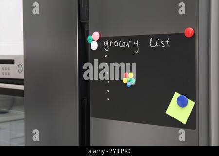 Tableau magnétique avec liste d'épicerie et note sur le réfrigérateur dans la cuisine Banque D'Images
