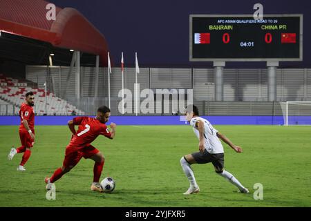 Riffa, Bahreïn. 14 novembre 2024. Ali Madan (avant, l) de Bahreïn participe au match des qualifications asiatiques du Groupe C de la Coupe du monde de la FIFA 2026 entre la Chine et Bahreïn à Riffa, Bahreïn, 14 novembre 2024. Crédit : Wang Haizhou/Xinhua/Alamy Live News Banque D'Images