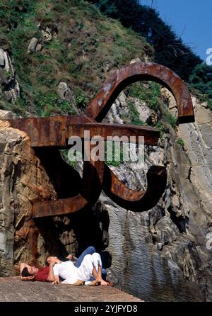 PAREJA DEBAJO DE LA ESCULTURA EL PEINE DE LOS VIENTOS. Auteur : EDUARDO CHILLIDA. Emplacement : EXTÉRIEUR. SAN SEBASTIAN. Guipuzcoa. ESPAGNE. Banque D'Images