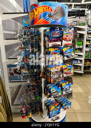 Kiev, Ukraine - 14 novembre 2024 : un présentoir coloré rempli de voitures jouets Hot Wheels dans un magasin de détail. Présenté sont différents modèles et collégial Banque D'Images