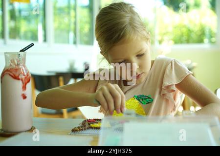 Professeur dans l'atelier a techno deux filles comment assembler une mosaïque thermo Banque D'Images