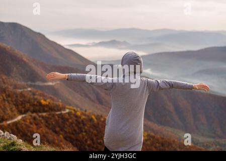 Femme heureuse appréciant la main levée ouverte sur le sommet de la montagne. Concept de liberté libre. Banque D'Images