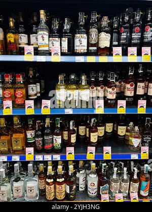 Kiev, Ukraine - 14 novembre 2024 : une étagère de magasin bien approvisionnée avec une gamme de bouteilles de rhum de différentes marques. Les étiquettes de prix sont visibles, indiquant dif Banque D'Images