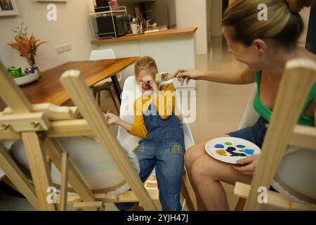 Professeur dans l'atelier a techno deux filles comment assembler une mosaïque thermo Banque D'Images