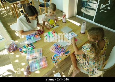 Professeur dans l'atelier a techno deux filles comment assembler une mosaïque thermo Banque D'Images