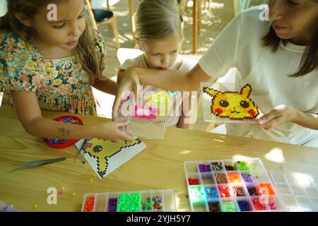 Professeur dans l'atelier a techno deux filles comment assembler une mosaïque thermo Banque D'Images