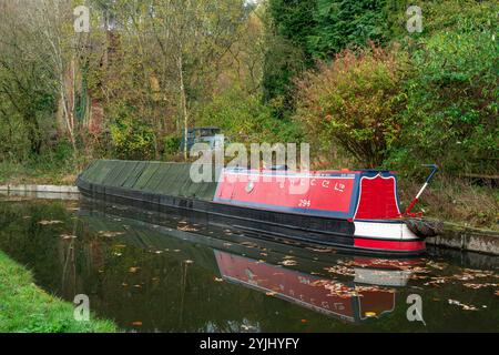 Froghall, STAFFORDSHIRE, ANGLETERRE - 11 NOVEMBRE 2024 : bateau étroit amarré sur le canal de Caldon par une maison en ruine et un vieux bateau délabré près de Froghall Wh Banque D'Images