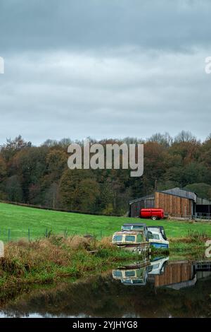 Bateaux amarrés le long de la voie navigable intérieure du canal Caldon près de Denford, Angleterre, Royaume-Uni. Banque D'Images