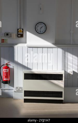 Dans la bibliothèque publique de Framlingham et ce qui était autrefois la salle d'audience la lumière du soleil de l'après-midi fait des ombres spectaculaires sur un mur et le chauffage de stockage. Banque D'Images