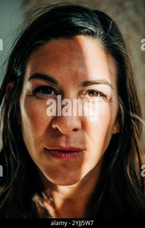 Gros plan du visage de la femme avec la lumière dramatique du soleil et des ombres Banque D'Images