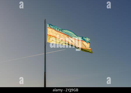 Un drapeau avec une bande bleue et une bande blanche vole dans le ciel Banque D'Images