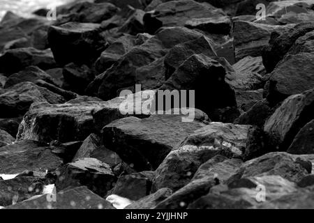 Photo en noir et blanc de roches humides représentant un paysage aride. En fait, c'est une zone rocheuse sur la rive de la mer Noire pendant une journée d'été orageuse. Banque D'Images