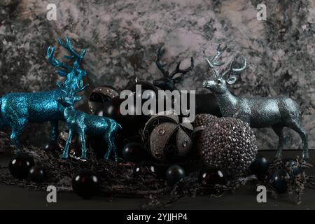 Figurines de cerfs métalliques et bleues entourées de décorations de Noël noires et argentées Banque D'Images