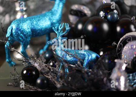 Figurines de cerfs métalliques et bleues entourées de décorations de Noël noires et argentées Banque D'Images