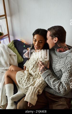 Le couple profite d’un moment chaleureux et intime ensemble par les décorations festives à la maison Banque D'Images