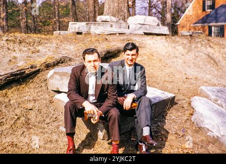 Deux hommes élégamment habillés assis dehors regardant la caméra, USA c 1953 Banque D'Images