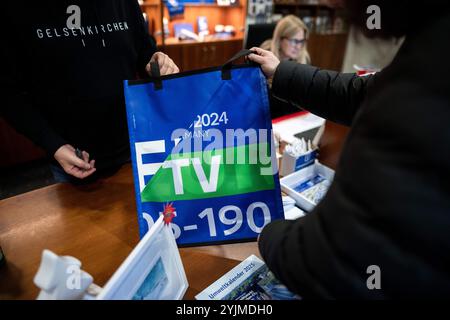 Gelsenkirchen, Allemagne. 15 novembre 2024. Un sac est montré à un client. Les produits fabriqués à partir de bannières, de bavoirs et de drapeaux du Championnat d'Europe sont maintenant vendus quatre mois après le Championnat d'Europe de football. Le projet est présenté par la ville et les partenaires de coopération. Les profits iront à une bonne cause. Crédit : Fabian Strauch/dpa/Alamy Live News Banque D'Images