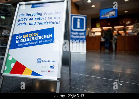 Gelsenkirchen, Allemagne. 15 novembre 2024. Un affichage devant la ville et des informations touristiques indiquant les produits. Les produits fabriqués à partir de bannières, de bavoirs et de drapeaux du Championnat d'Europe sont maintenant vendus quatre mois après le Championnat d'Europe de football. Le projet est présenté par la ville et les partenaires de coopération. Les profits iront à une bonne cause. Crédit : Fabian Strauch/dpa/Alamy Live News Banque D'Images