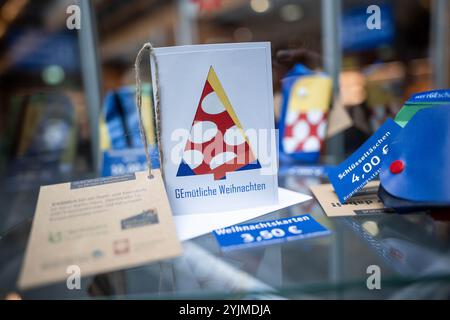 Gelsenkirchen, Allemagne. 15 novembre 2024. Une carte de Noël se tient dans une vitrine. Les produits fabriqués à partir de bannières, de bavoirs et de drapeaux du Championnat d'Europe sont maintenant vendus quatre mois après le Championnat d'Europe de football. Le projet est présenté par la ville et les partenaires de coopération. Les profits iront à une bonne cause. Crédit : Fabian Strauch/dpa/Alamy Live News Banque D'Images