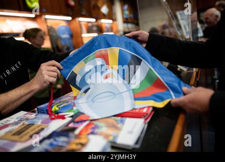 Gelsenkirchen, Allemagne. 15 novembre 2024. Un sac fabriqué à partir des matériaux du Championnat d'Europe est remis sur le comptoir. Les produits fabriqués à partir de bannières, de bavoirs et de drapeaux du Championnat d'Europe sont maintenant vendus quatre mois après le Championnat d'Europe de football. Le projet est présenté par la ville et les partenaires de coopération. Les profits iront à une bonne cause. Crédit : Fabian Strauch/dpa/Alamy Live News Banque D'Images