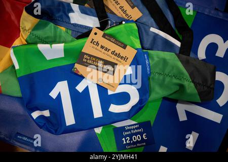 Gelsenkirchen, Allemagne. 15 novembre 2024. Les sacs fabriqués à partir de matériaux du Championnat d'Europe reposent sur une table. Les produits fabriqués à partir de bannières, de bavoirs et de drapeaux du Championnat d'Europe sont maintenant vendus quatre mois après le Championnat d'Europe de football. Le projet est présenté par la ville et les partenaires de coopération. Les profits iront à une bonne cause. Crédit : Fabian Strauch/dpa/Alamy Live News Banque D'Images