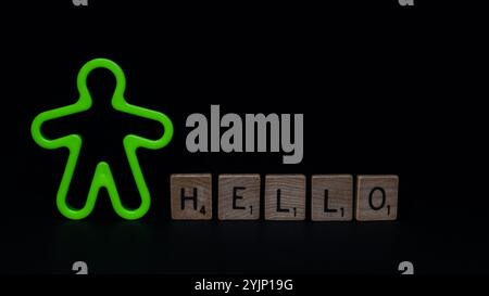 Gros plan de l'homme en plastique vert fluorescent avec des lettres "HELLO" sur la surface noire. Banque D'Images