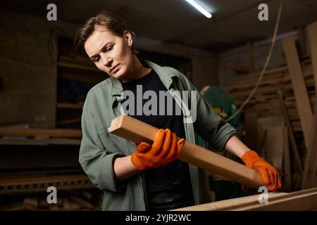 Une femme menuisière qualifiée se concentre intensément sur son projet de menuiserie tout en étant entourée d'outils et de matériaux. Banque D'Images