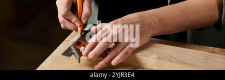 Concentrée sur son travail, une menuisière marque soigneusement les mesures sur le bois dans un espace d’atelier bien éclairé. Banque D'Images