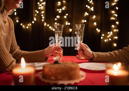 Jeune couple amoureux ayant un dîner romantique à la maison levant des verres de vin en dégustant de la nourriture délicieuse célébrant la Saint-Valentin. mari et femme Banque D'Images