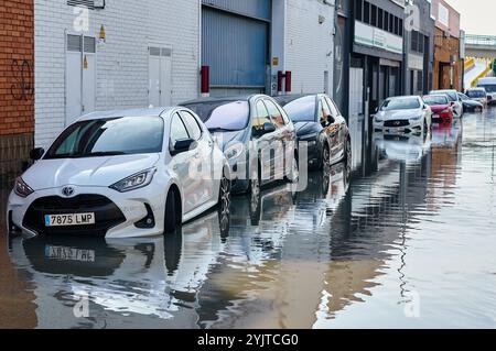 Viladecans. Espagne - 15 novembre 2024 : une rue urbaine est inondée d'eau atteignant les roues des voitures. L'image capture les conséquences des inondations de HE Banque D'Images