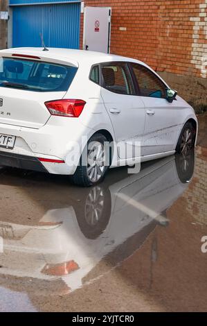 Viladecans. Espagne - 15 novembre 2024 : des véhicules sont vus en eau profonde sur une route urbaine, submergés à mi-hauteur de leurs roues. L'image met l'accent sur l'ef Banque D'Images