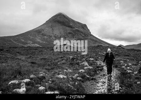 Une femme âgée faisant une randonnée à travers les Hiills/montagnes de Cuillin sur la promenade de Sligachan à Elgol, île de Skye, Écosse, Royaume-Uni. Banque D'Images