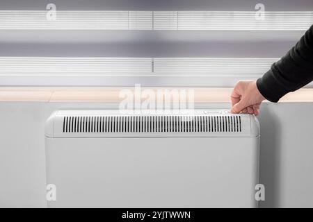 Chauffage électrique. Radiateur mural électrique placé sous une fenêtre. Banque D'Images